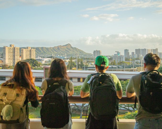 Interior of the UH Mānoa library with students studying among bookshelves