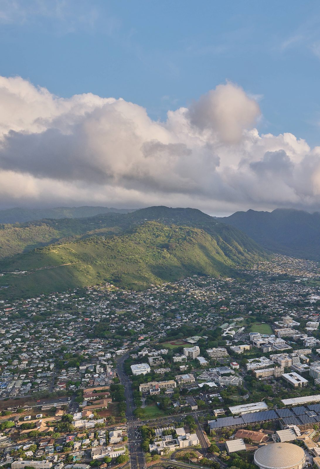 Students walking across the UH Mānoa campus on a sunny day